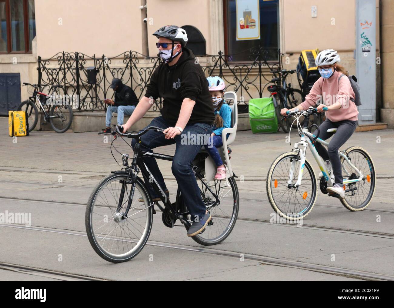 Cracow. Krakow. Poland. Father with two children riding the bikes in masks. Stock Photo