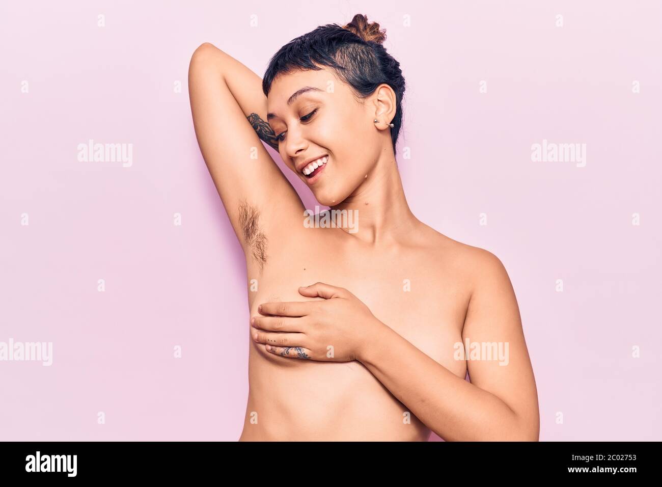 Young beautiful woman shirtless smiling happy. Standing with smile on face  showing hairy armpit over isolated pink background Stock Photo - Alamy