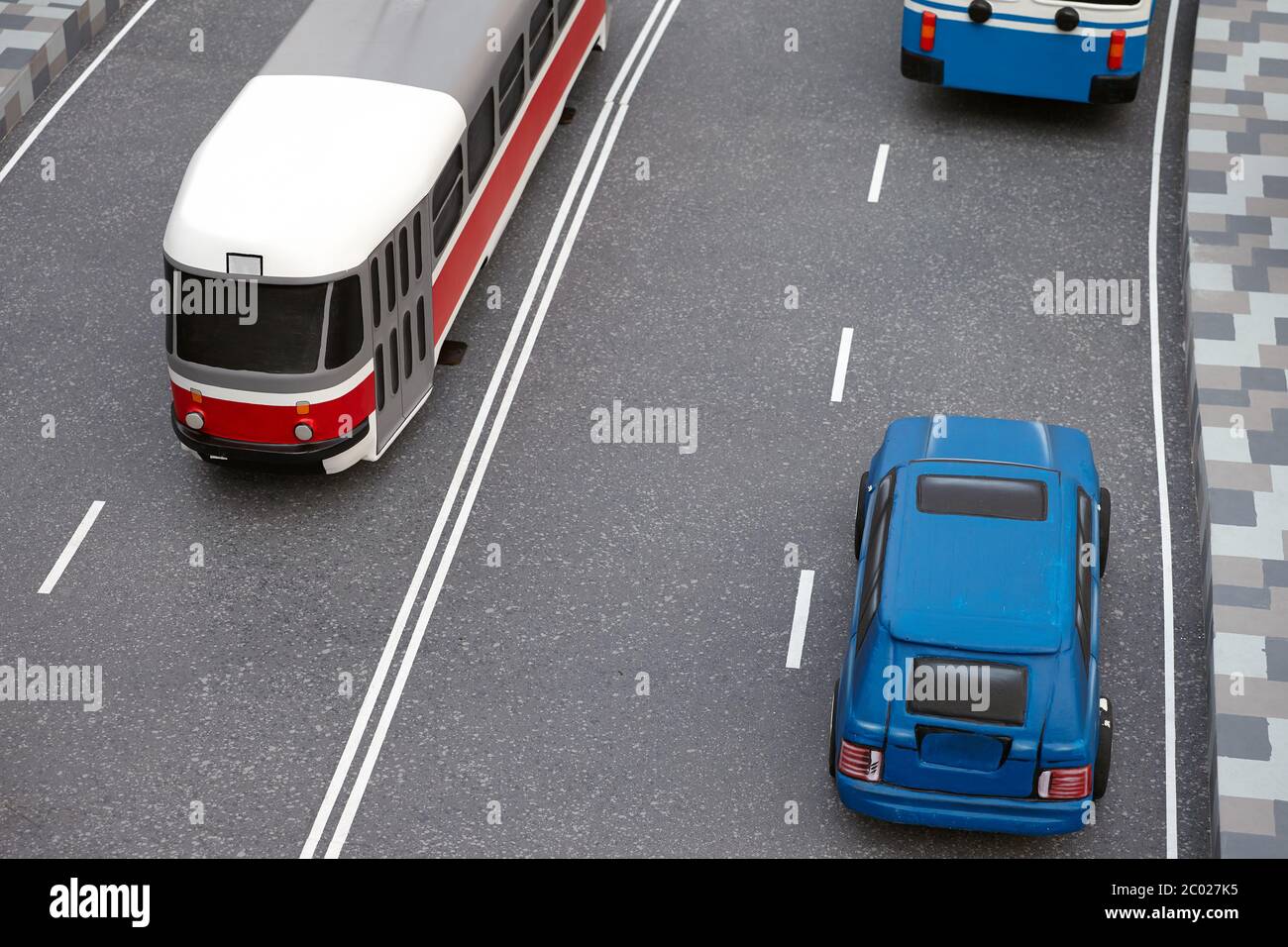 road traffic miniature with toy models of a modern tram, car and trolley bus Stock Photo