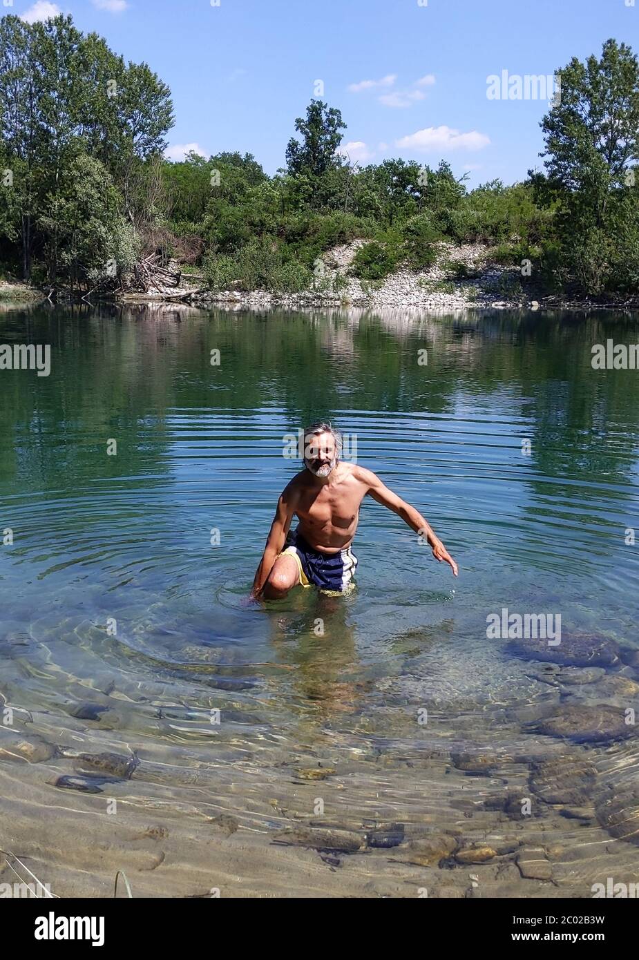happy mature man taking bath in a clear river Stock Photo