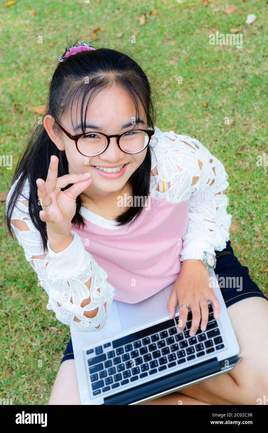Lovely girl with a laptop on the grass Stock Photo - Alamy