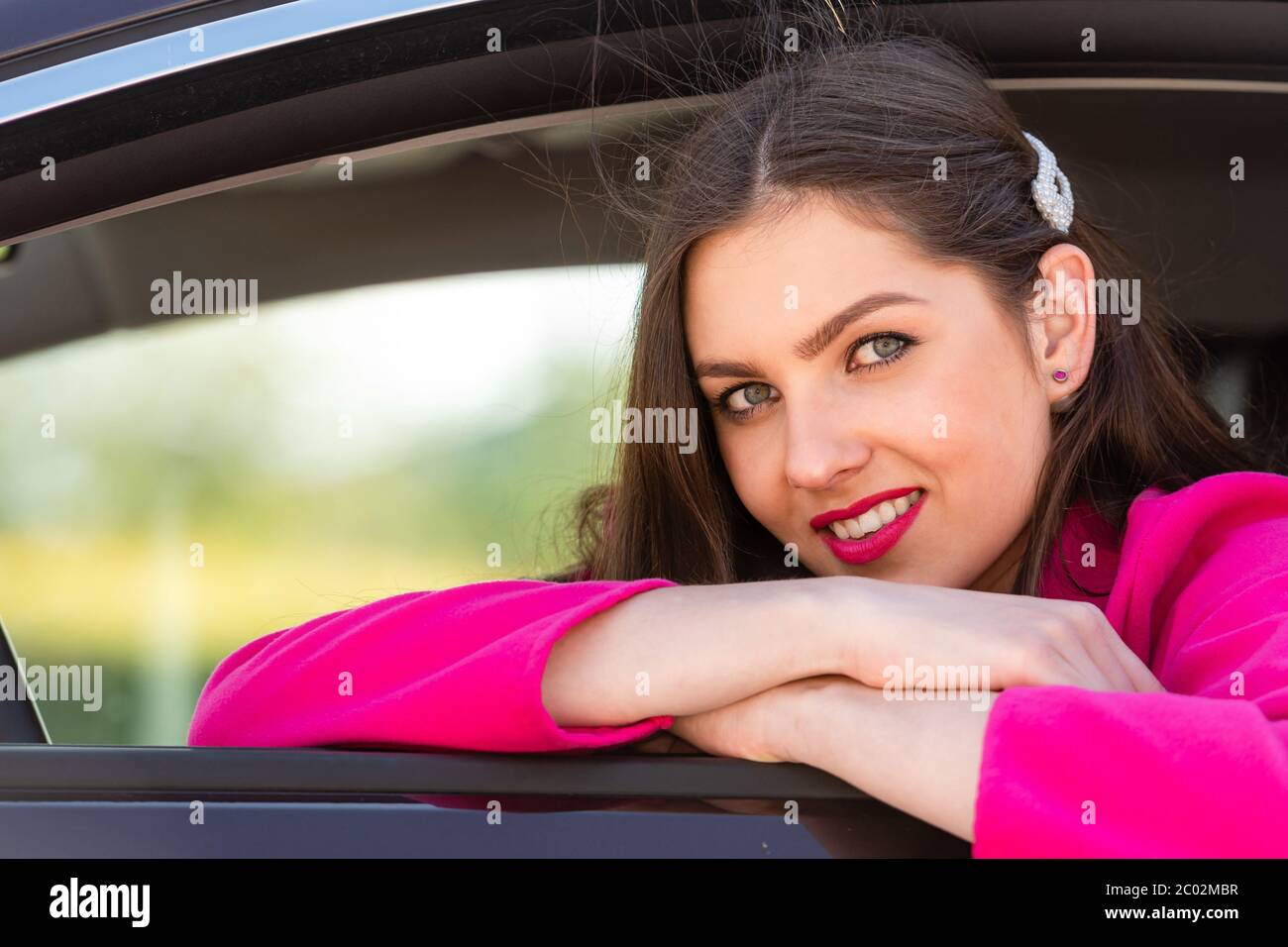a young, beautiful, emotional business woman, sitting in a car and looking out the window Stock Photo