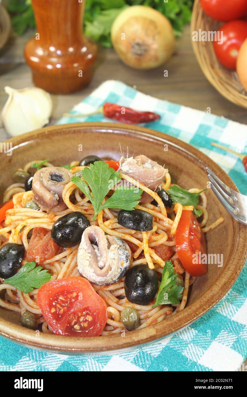 Spaghetti alla puttanesca with olives and anchovie Stock Photo