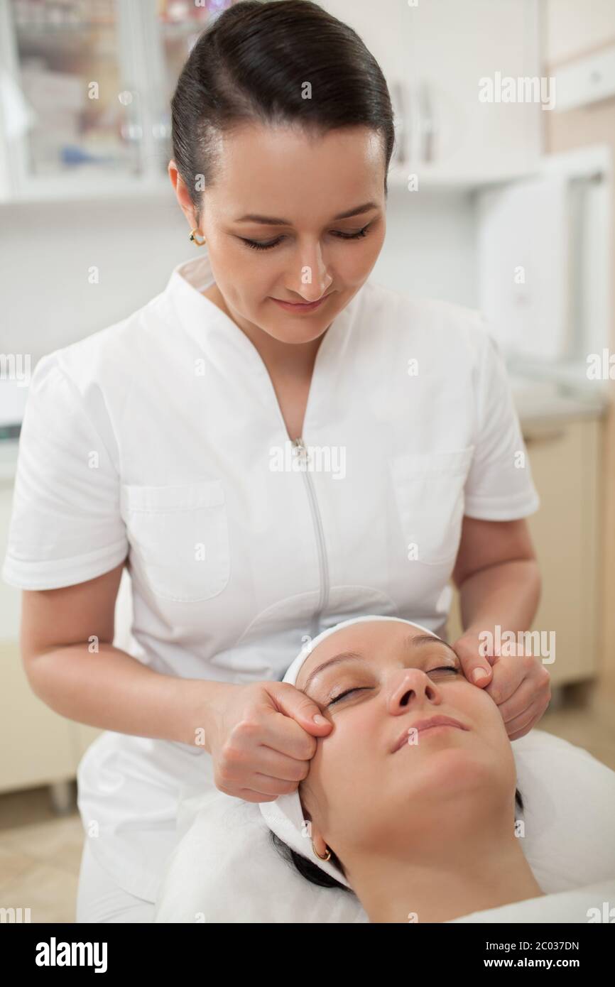 Woman under facial massage at beauty spa Stock Photo