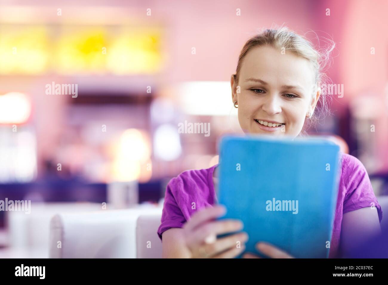 Woman using tablet PC in the restaurant indoors Stock Photo