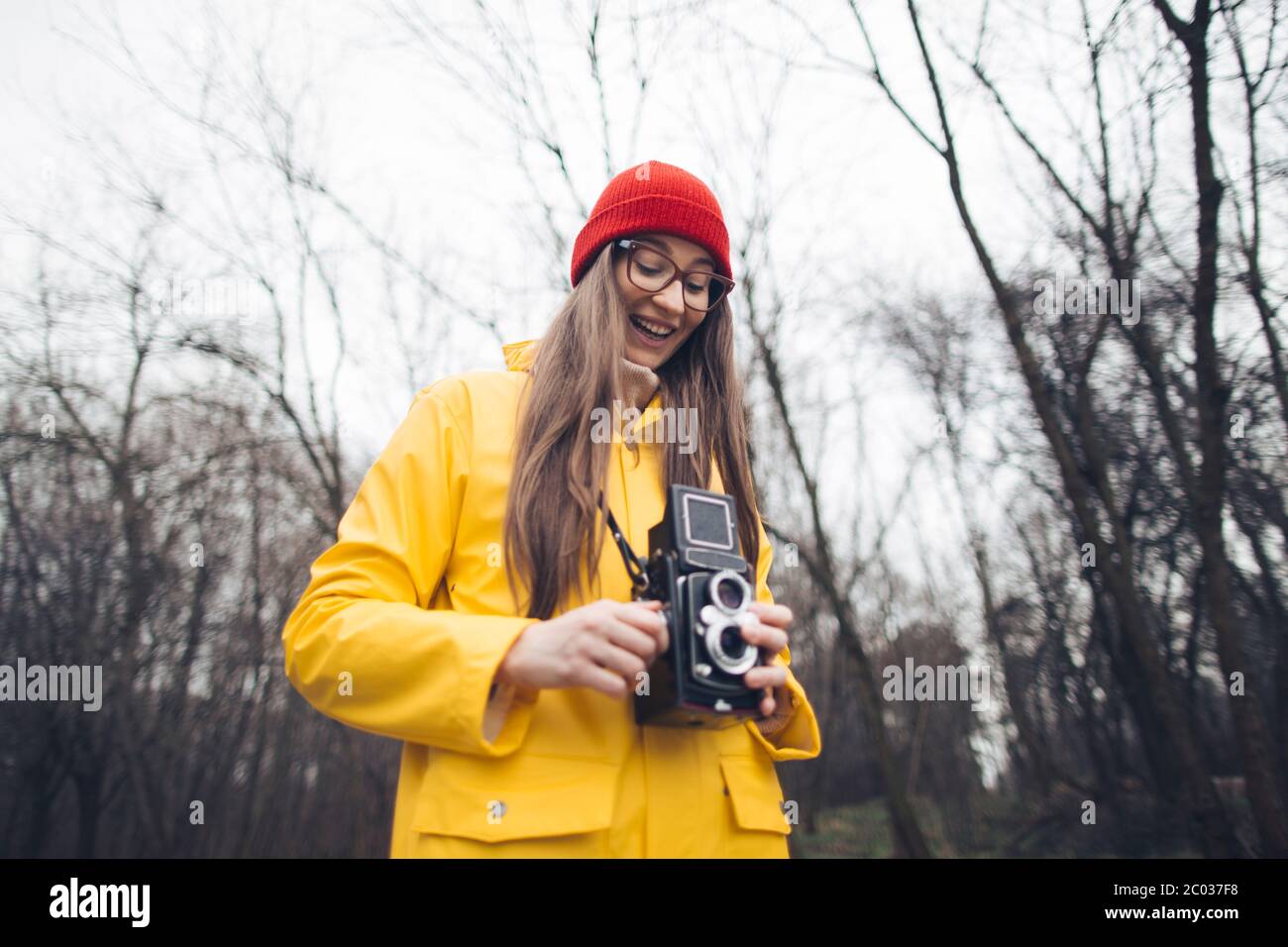 Woman photographer in yellow raincoat 