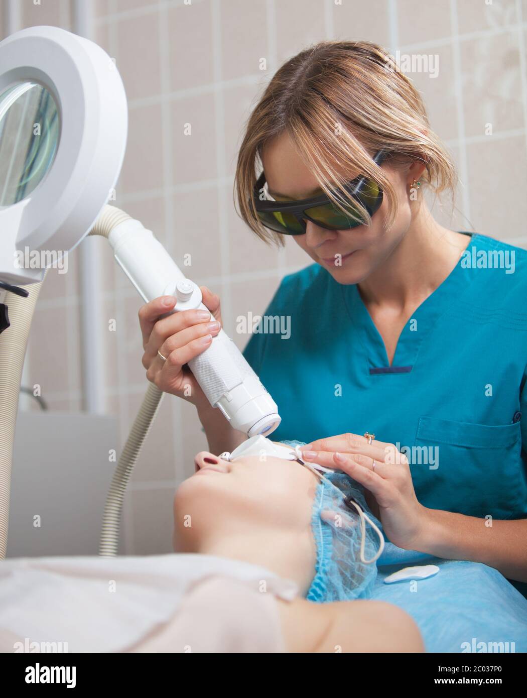 Cosmetician providing facial treatment with a laser Stock Photo