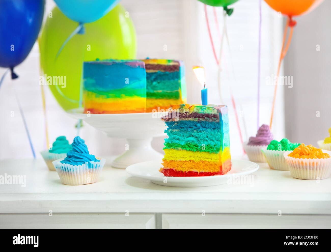 Rainbow cake decorated with birthday candle Stock Photo Alamy