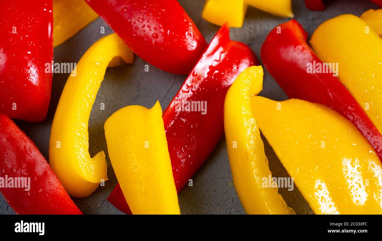 Sliced sweet bell pepper for healthy on dark background. Fresh washed slices of bellpepper. Red and yellow peppers Stock Photo