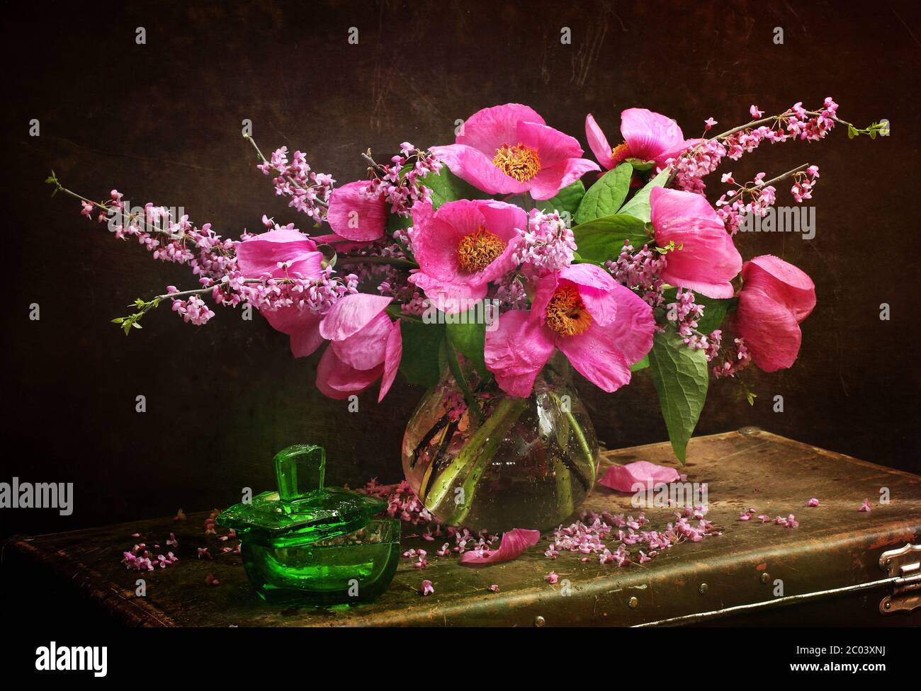 Peonies in a transparent vase and a green bottle Stock Photo