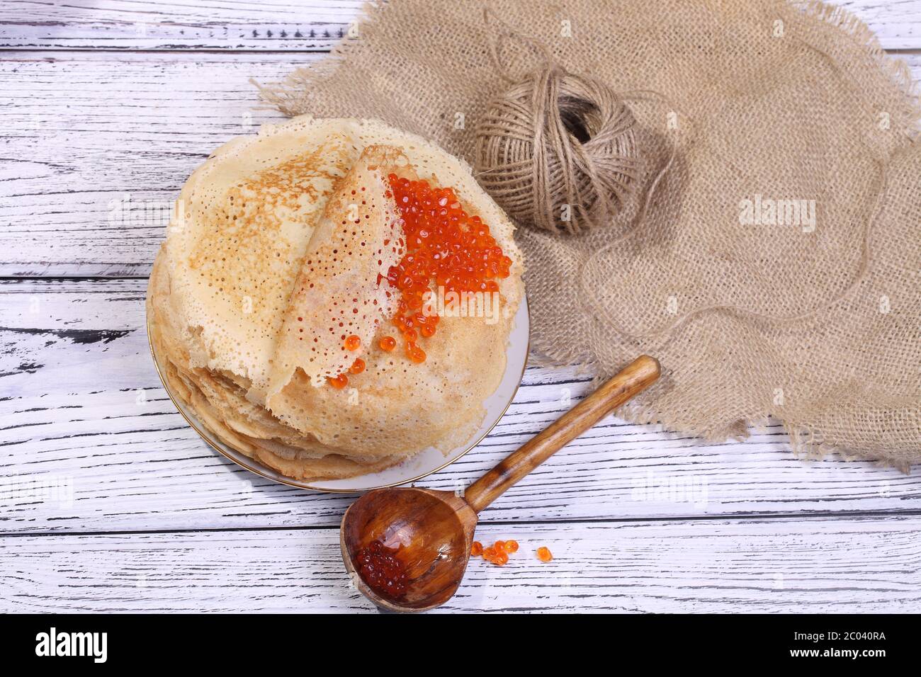 https://c8.alamy.com/comp/2C040RA/pancakes-with-red-caviar-and-a-wooden-spoon-2C040RA.jpg