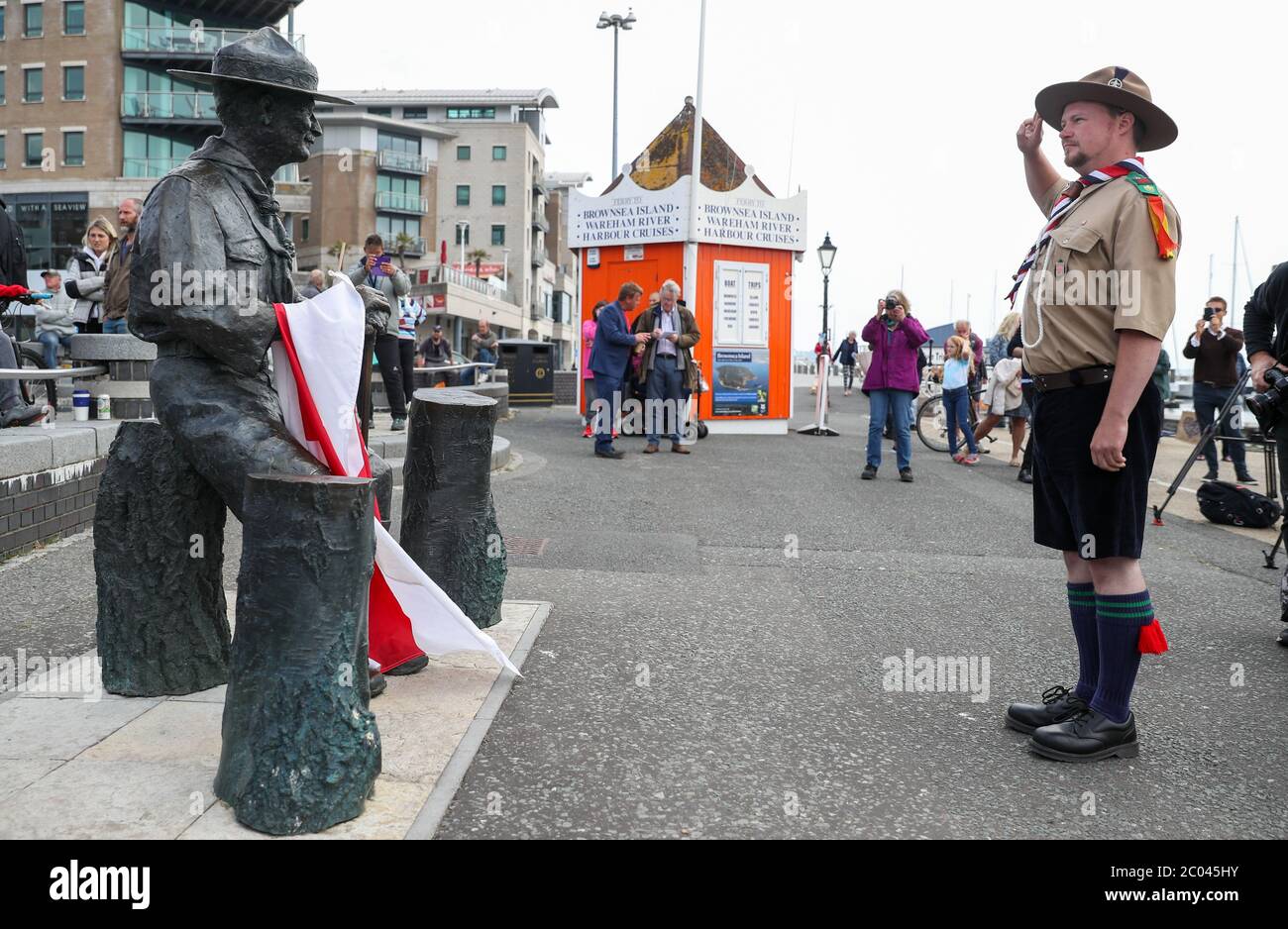 Rover Scout Matthew Trott salutes a statue of Robert Baden-Powell on Poole Quay in Dorset ahead of its expected removal to 'safe storage' following concerns about his actions while in the military and 'Nazi sympathies'. The action follows a raft of Black Lives Matter protests across the UK, sparked by the death of George Floyd, who was killed on May 25 while in police custody in the US city of Minneapolis. Stock Photo