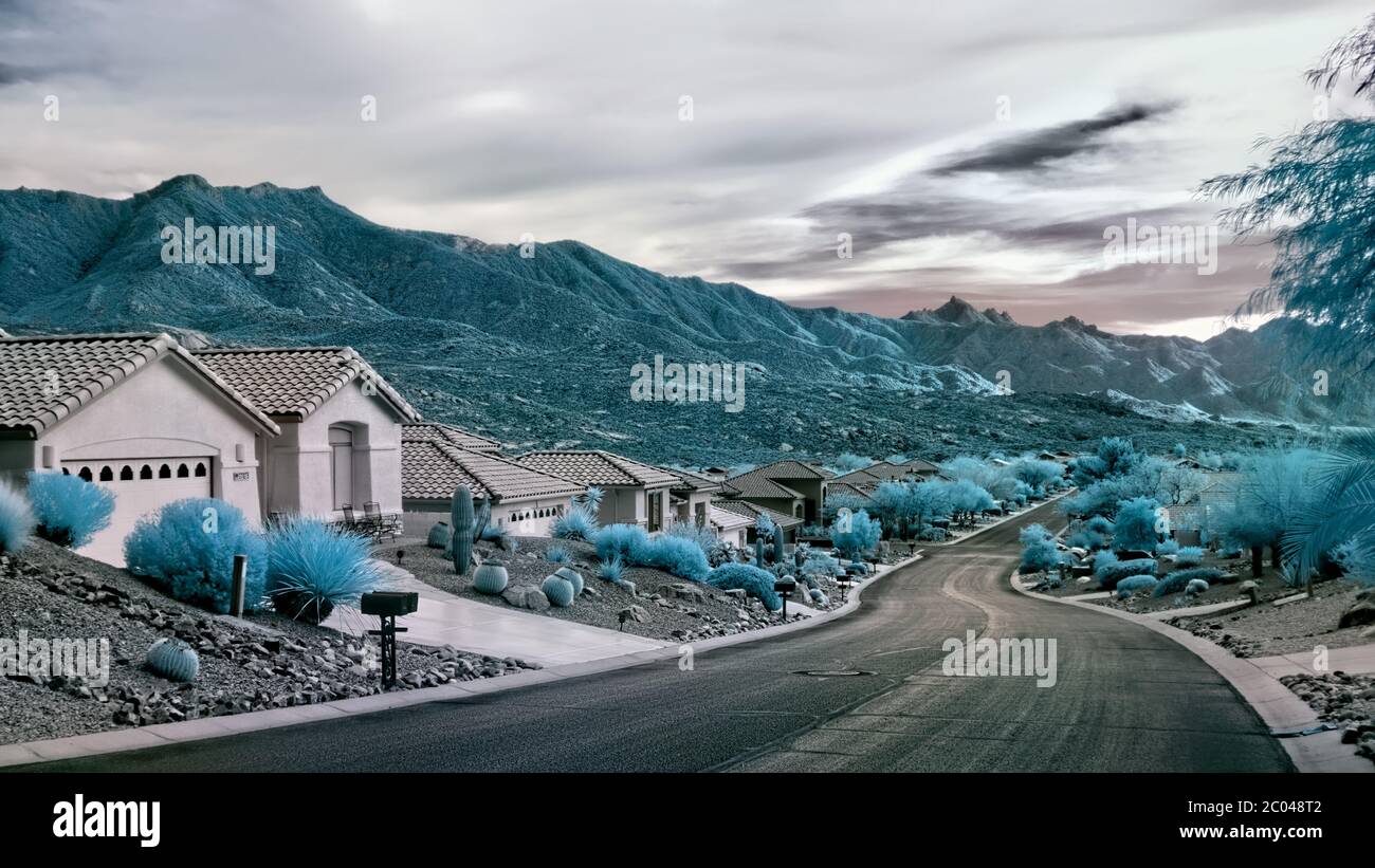 Infrared 560nm photograph of a street in the Sadlebrooke development of Pinal County, AZ with arid landscaping, home and mountains in the background Stock Photo