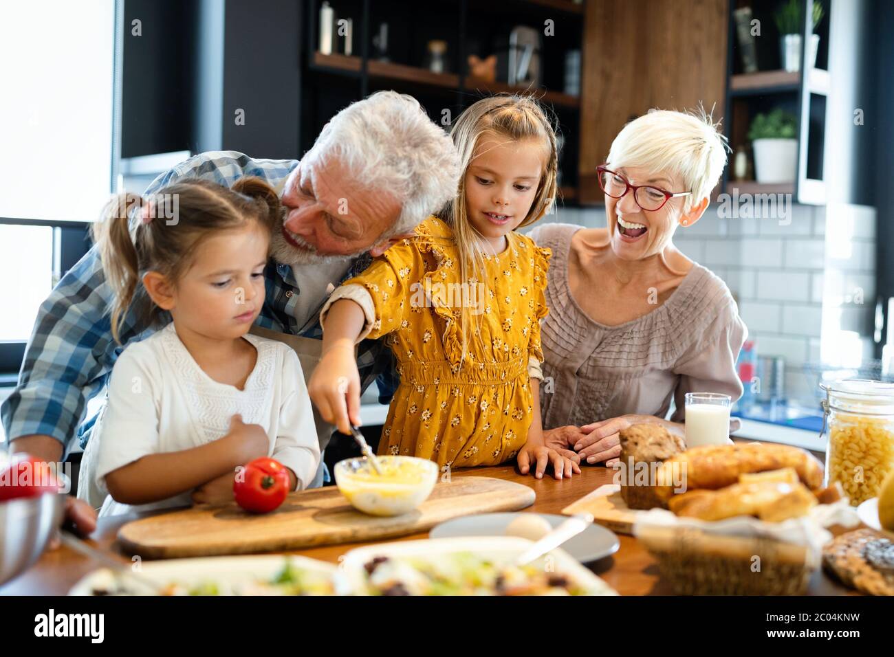 Happy grandparents having fun times with children at home Stock Photo