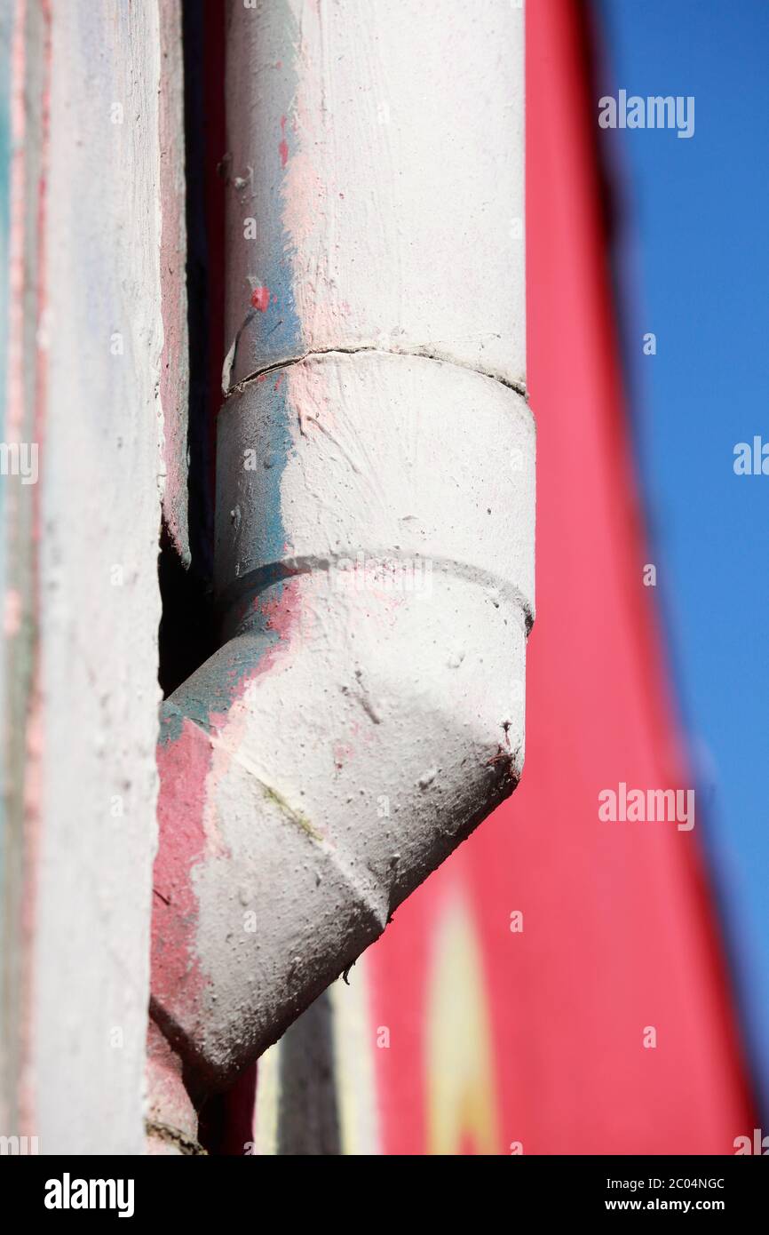 old white water pipe made of metal, colorful background, colorful wall