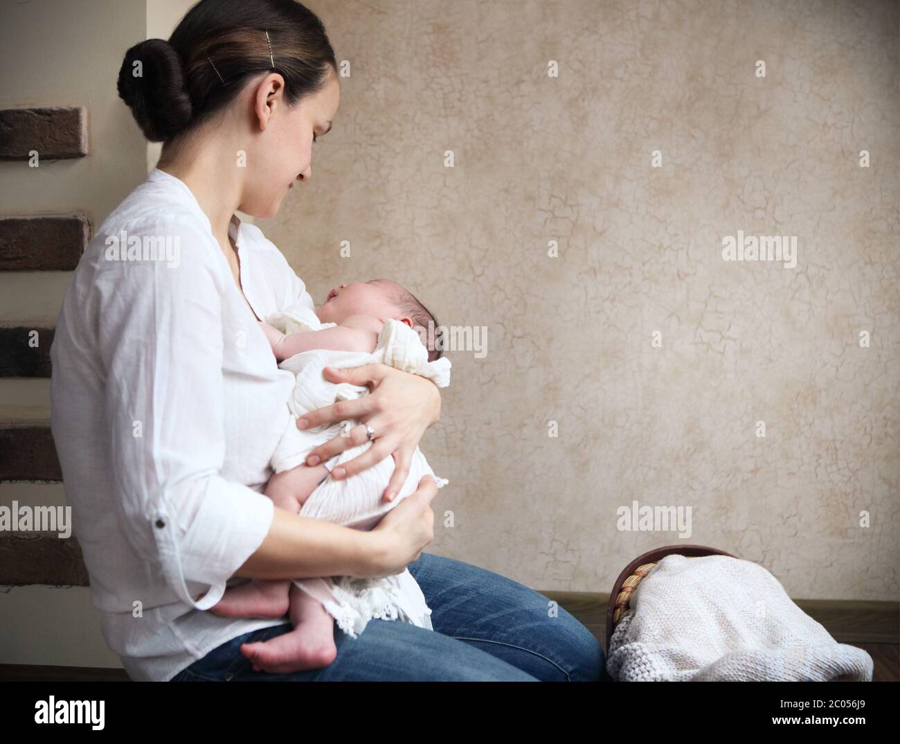 Baby falling asleep in the arms of her mother Stock Photo Alamy