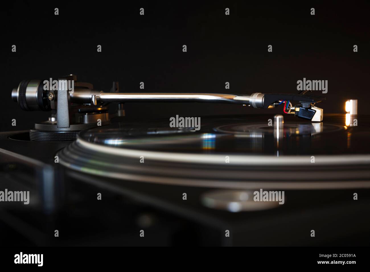 Vinyl record spinning on modern turntable. Black background. Space for text. Play music concept. Stock Photo