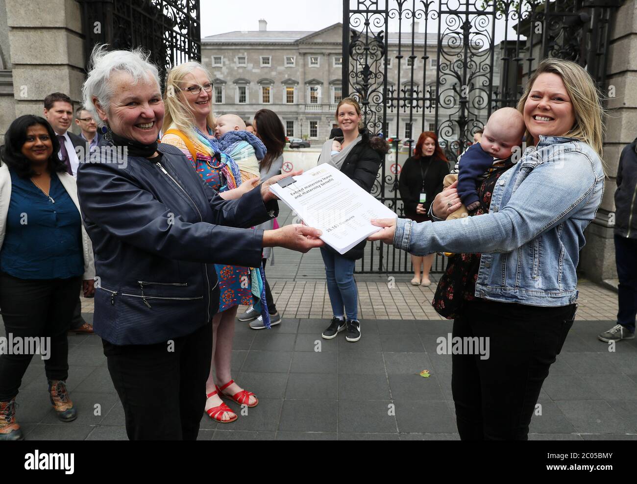 Tara MacDarby (right), with her son Calum (4months), presents People Before Profit's Brid Smith with a petition for Taoiseach Leo Varadkar calling for an extension of maternity leave for 3 months due to the Covid-19 crisis at Leinster House in Dublin. Stock Photo