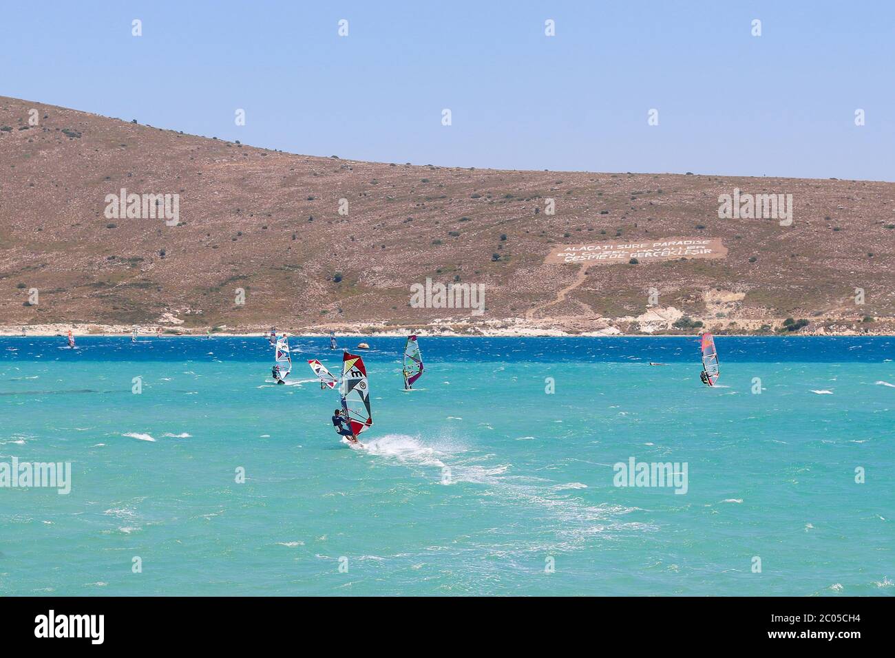 Surfer making speed and splashing water during preparation session for PWA World Tour Windsurfing Competition in Alacati. Stock Photo