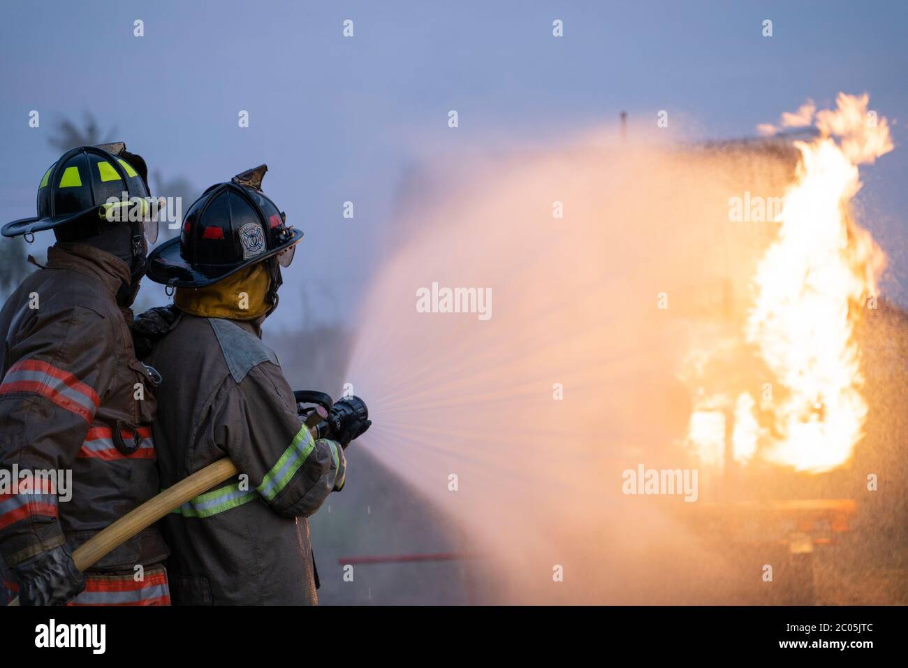 Firefighters fight against the raging fire from the fuel tank Stock