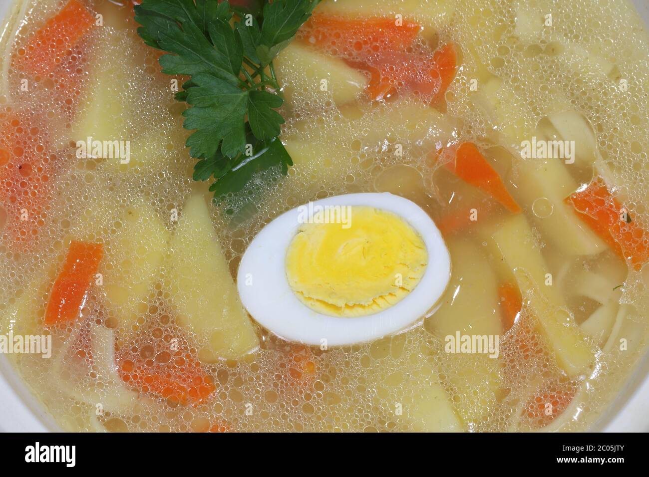 Chicken soup with house noodles and boiled egg Stock Photo