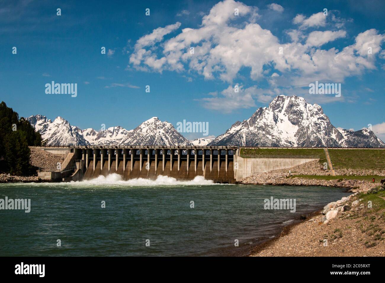 The Jackson Lake Dam with the snow capped Teton Mountain Range at Grand