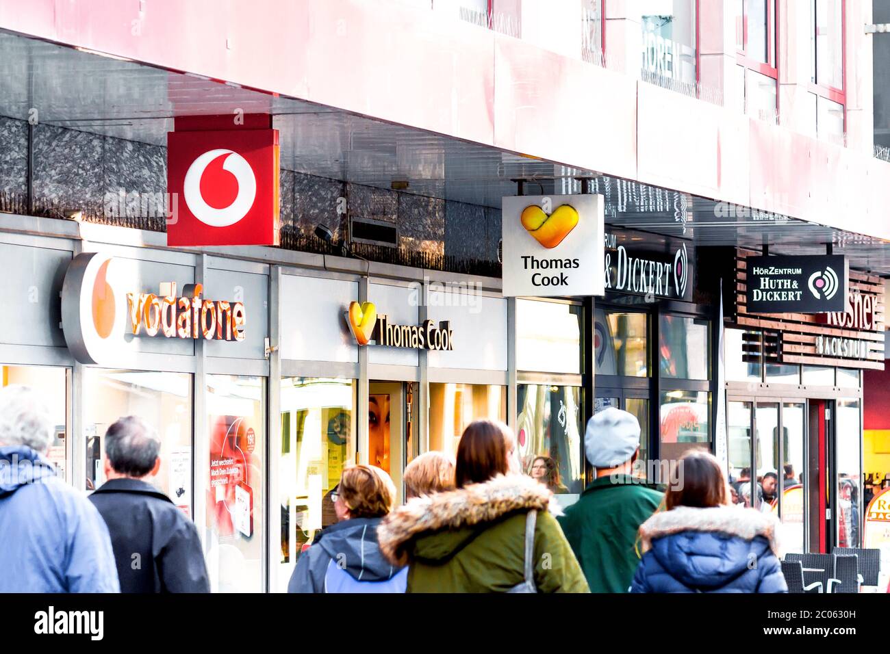People in colorful jackets walking down the Eichhorn street. On the background is the shopwindow of the famous travel agents branch Thomas Cook. Stock Photo