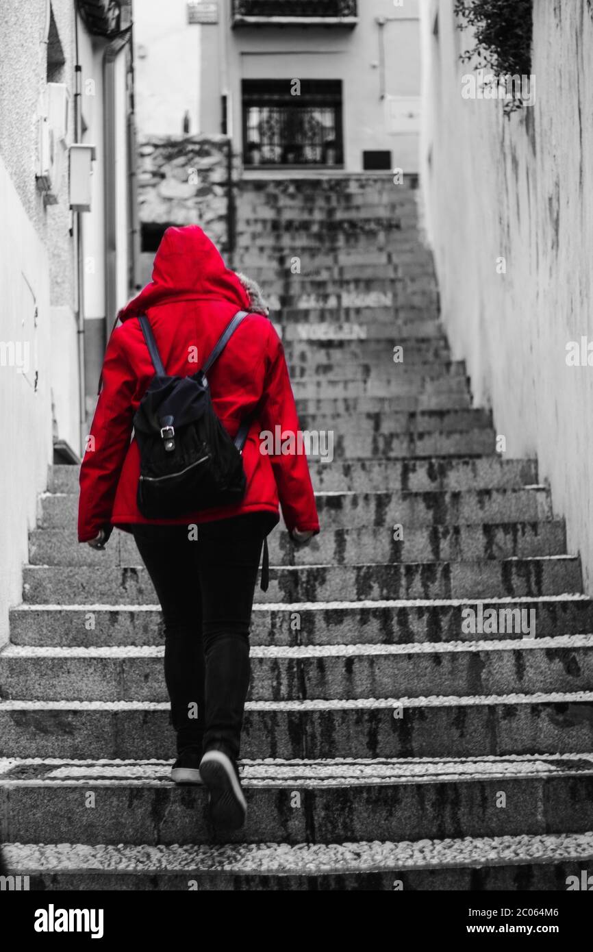 Girl with a red coat going upstairs. Stock Photo