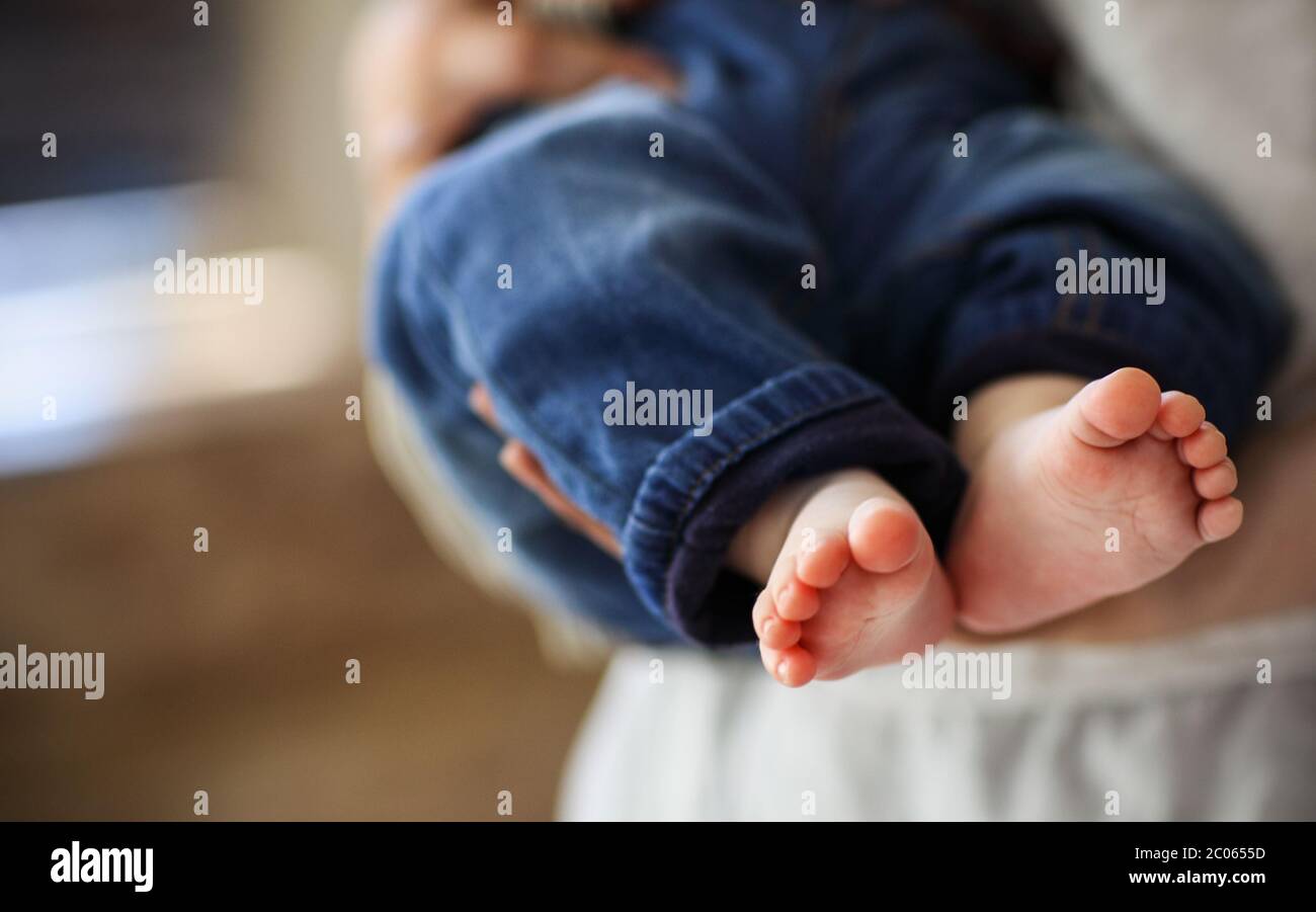 Baby boy falling asleep in the arms of her mother Stock Photo Alamy