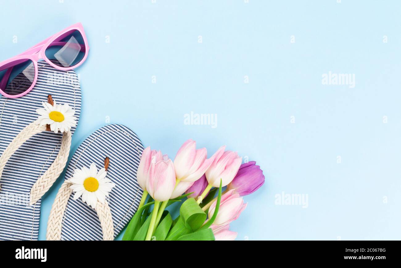 Beach flip flops with flowers and sunglasses on blue background. Summer ...