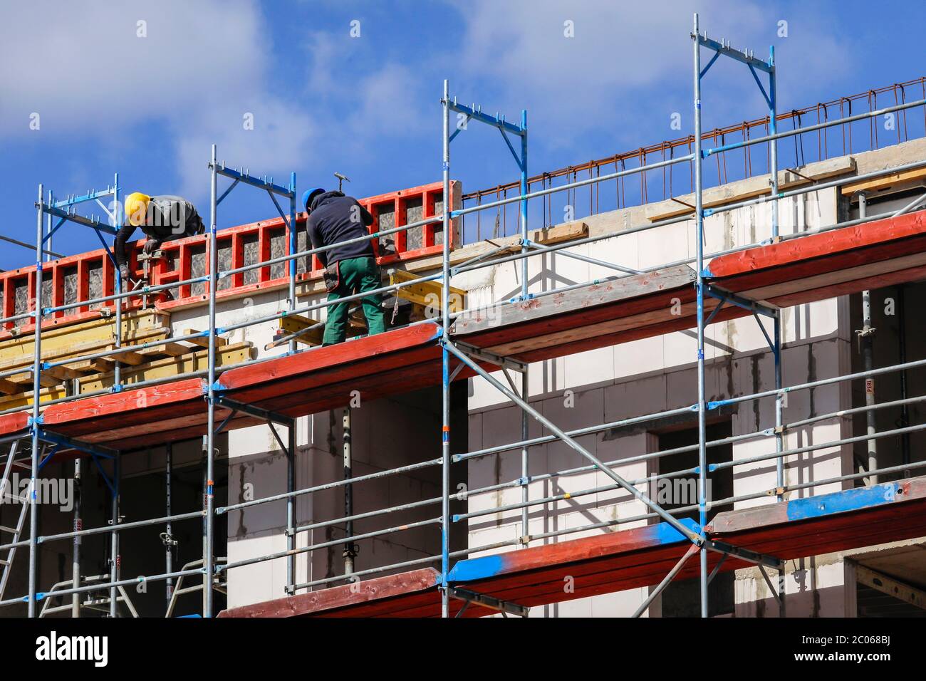 Construction worker on scaffolding, new construction of apartment buildings construction site, Essen, North Rhine-Westphalia, Germany Stock Photo