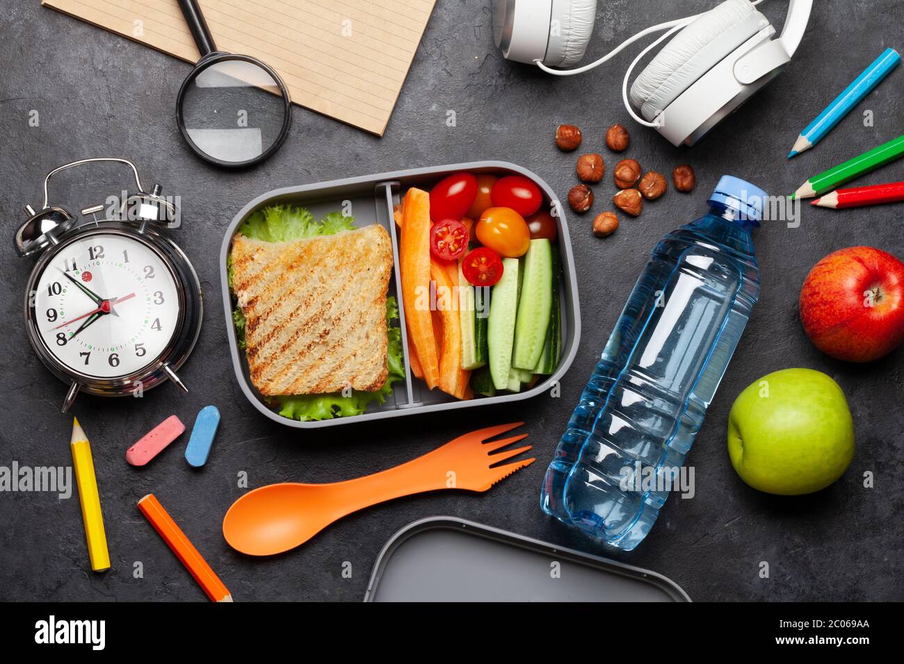 School lunch box and education stationery on stone table. Top view ...