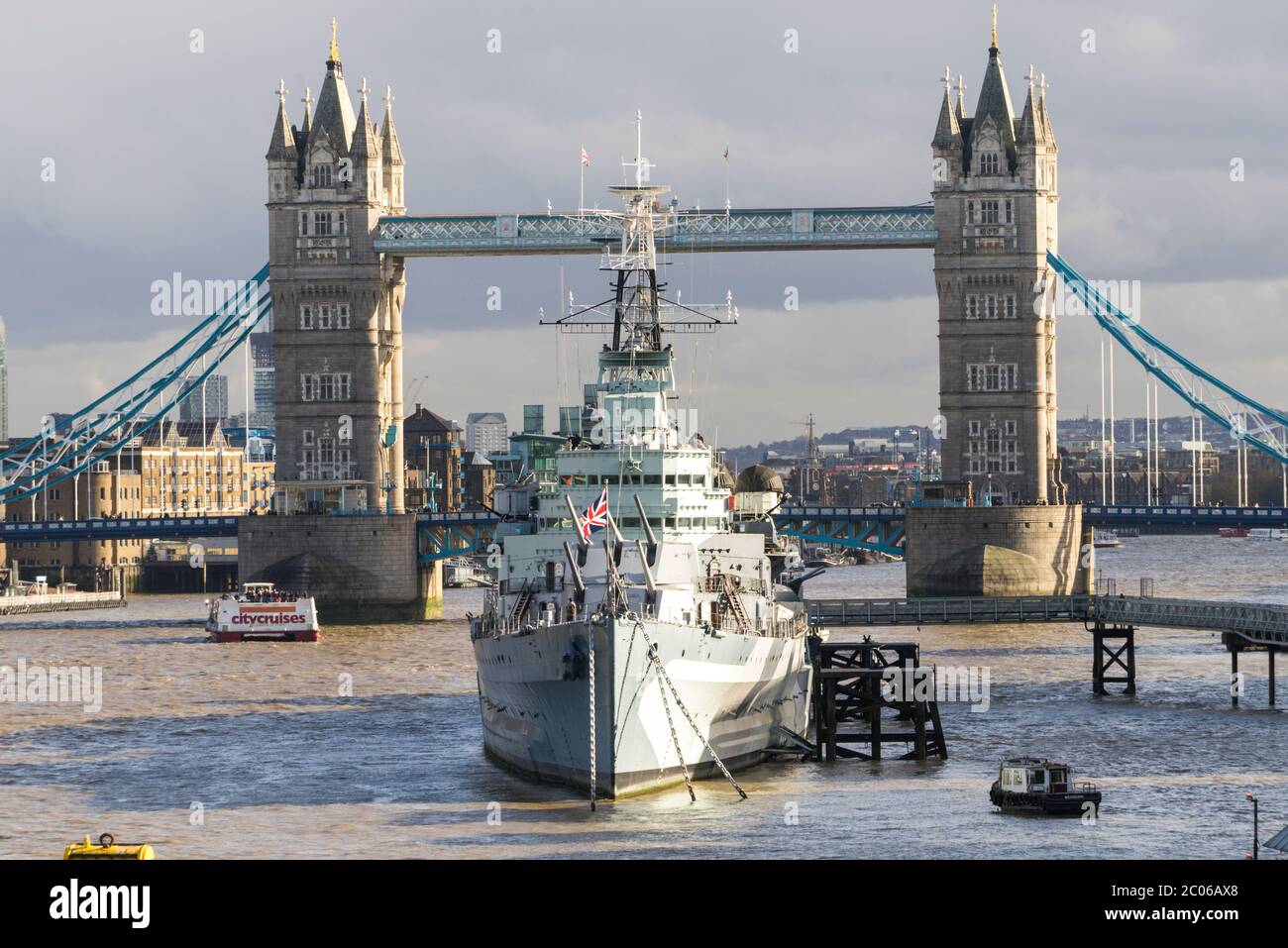 HMS Belfast, docked on the Thames in London, with Tower Bridge in the background a WWII ship that fired some of the first shots at the D-Day landings Stock Photo