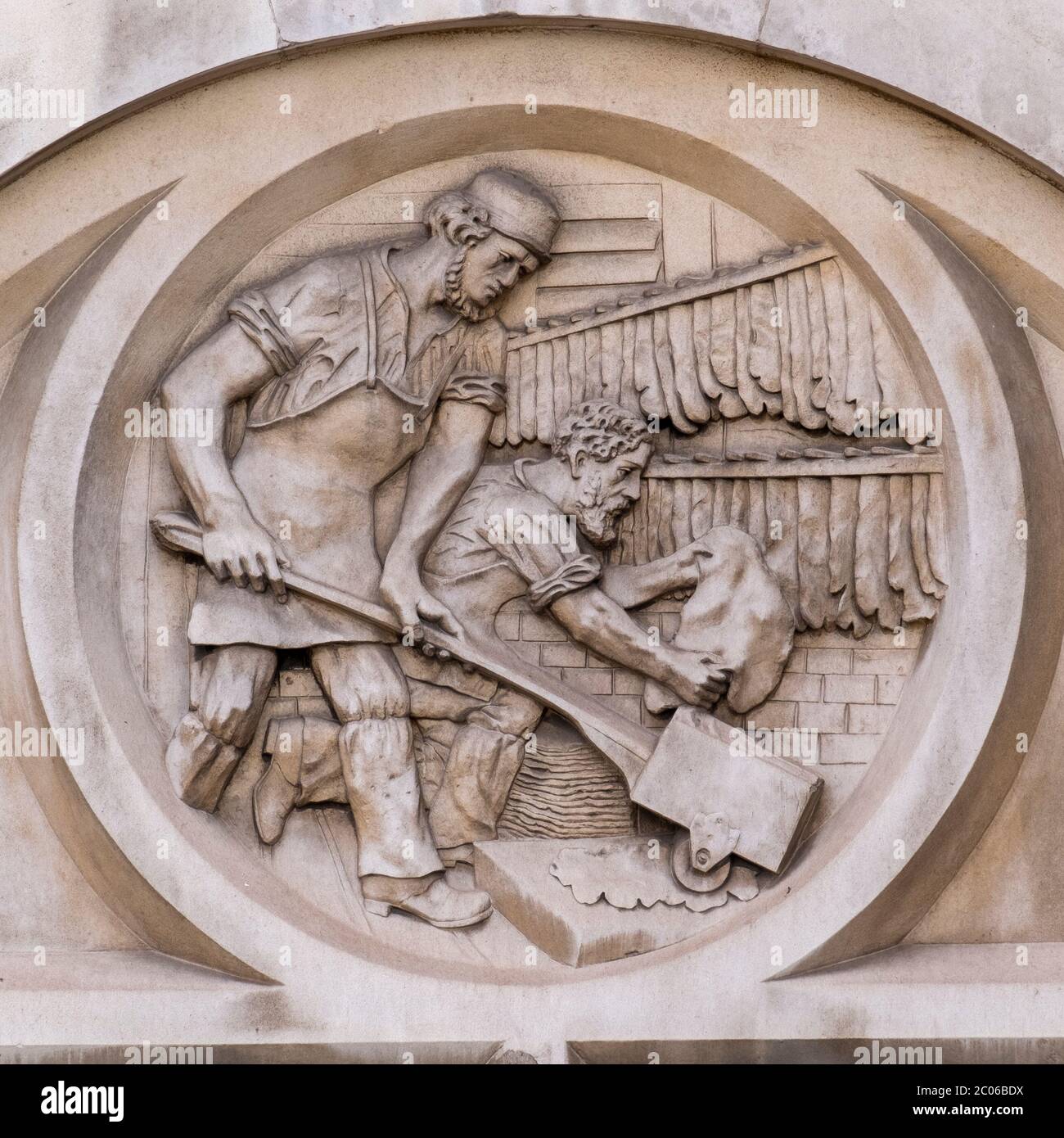 Embossed round frieze, one of 5, showing the leather tanning process on the Victorian London Leather Hide and Wool Exchange building 1878, Bermondsey. Stock Photo
