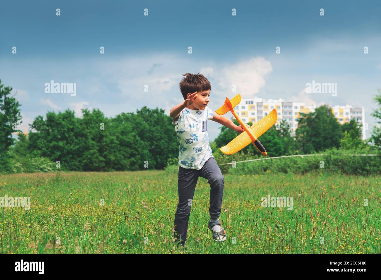 Happy kid playing with toy airplane against stormy summer sky Stock ...