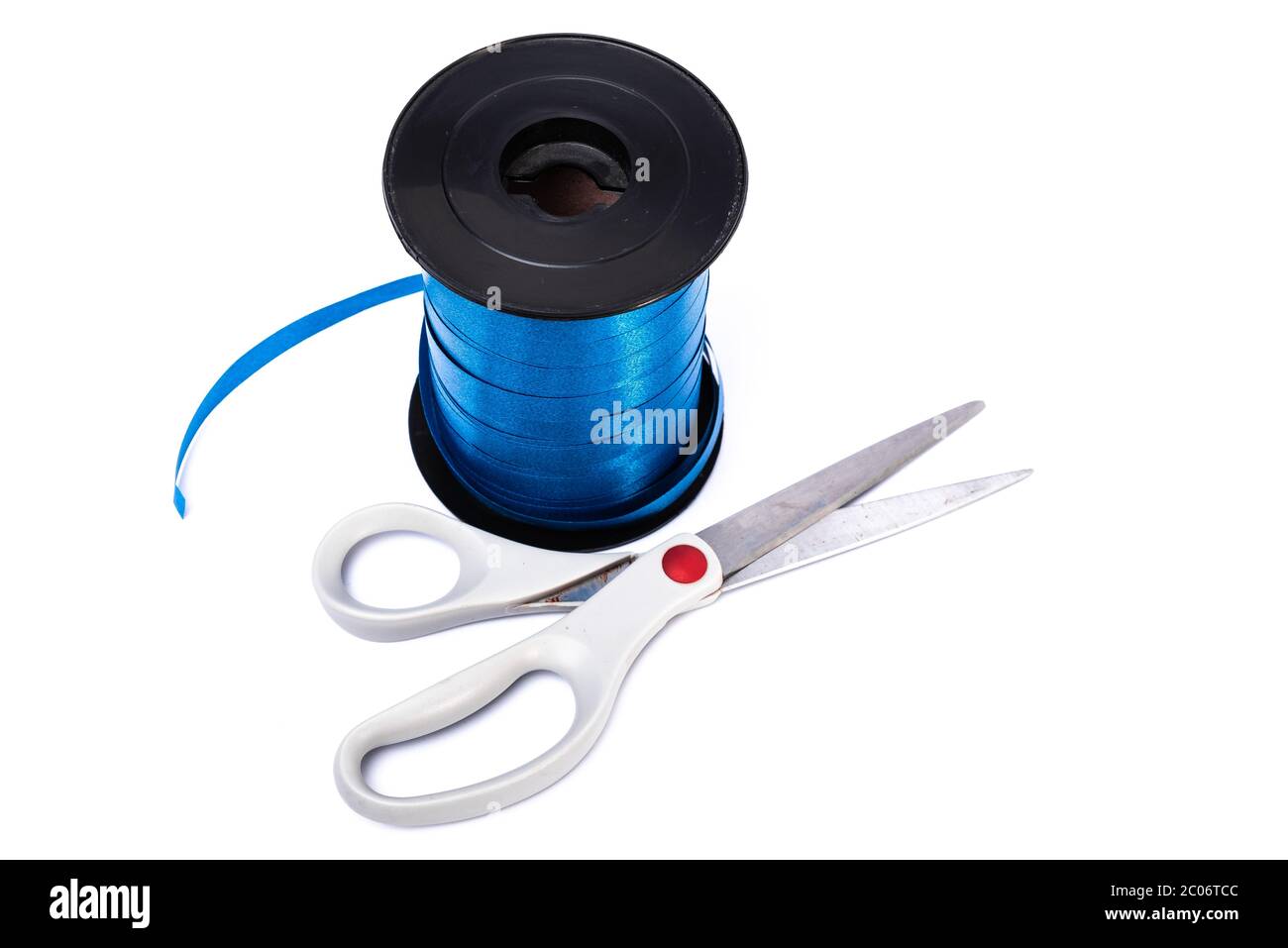 a roll of blue decorative ribbon with scissors on a white background ...