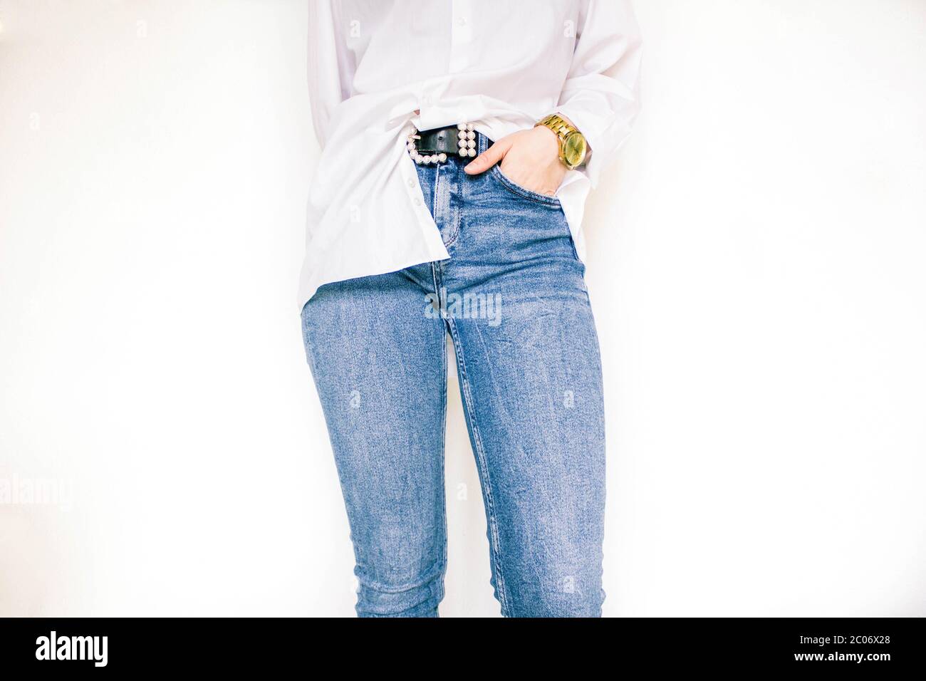 female body part, white shirt, jeans and watch on the wrist Stock Photo