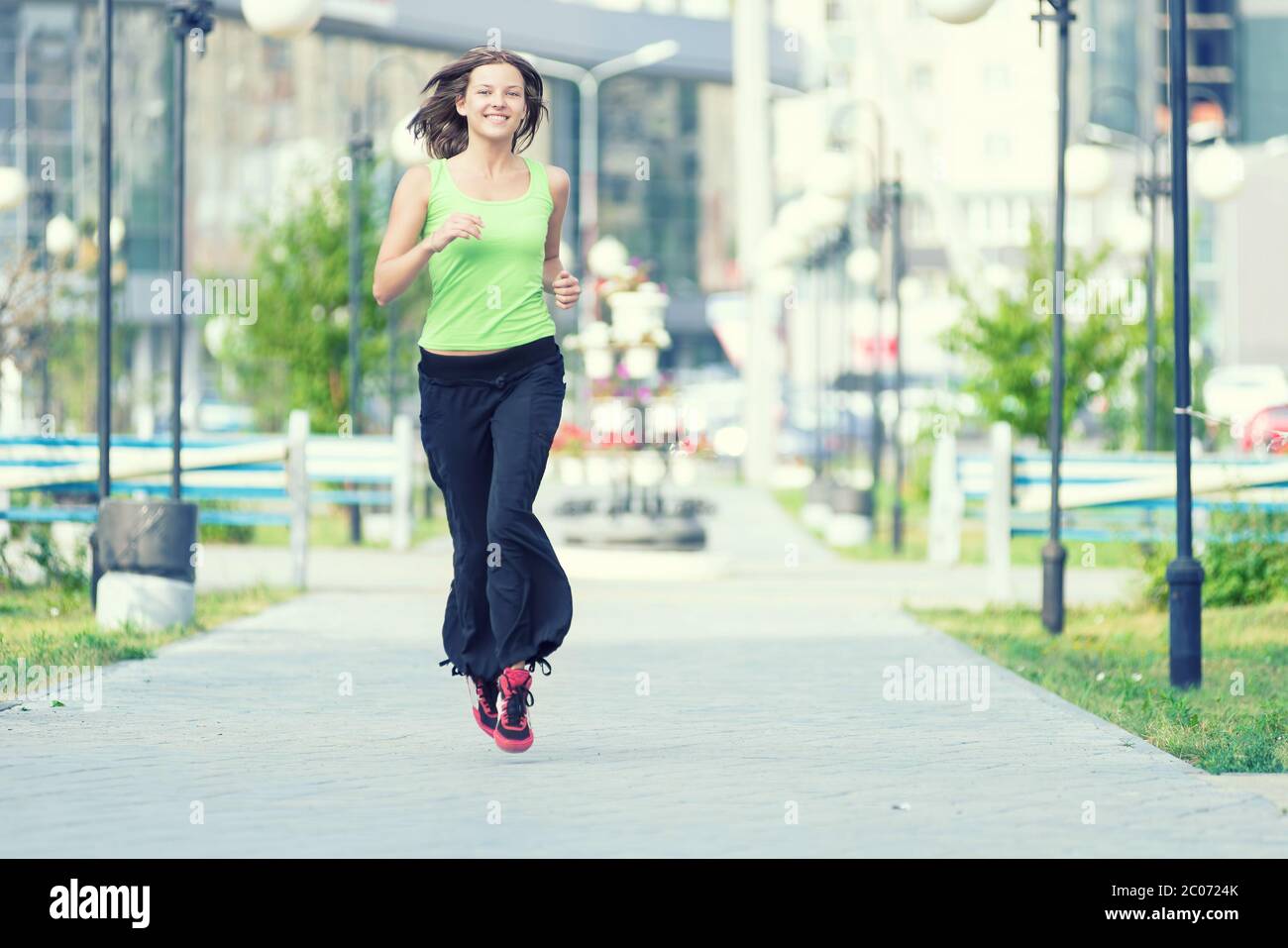 Woman jogging in city street park. Stock Photo