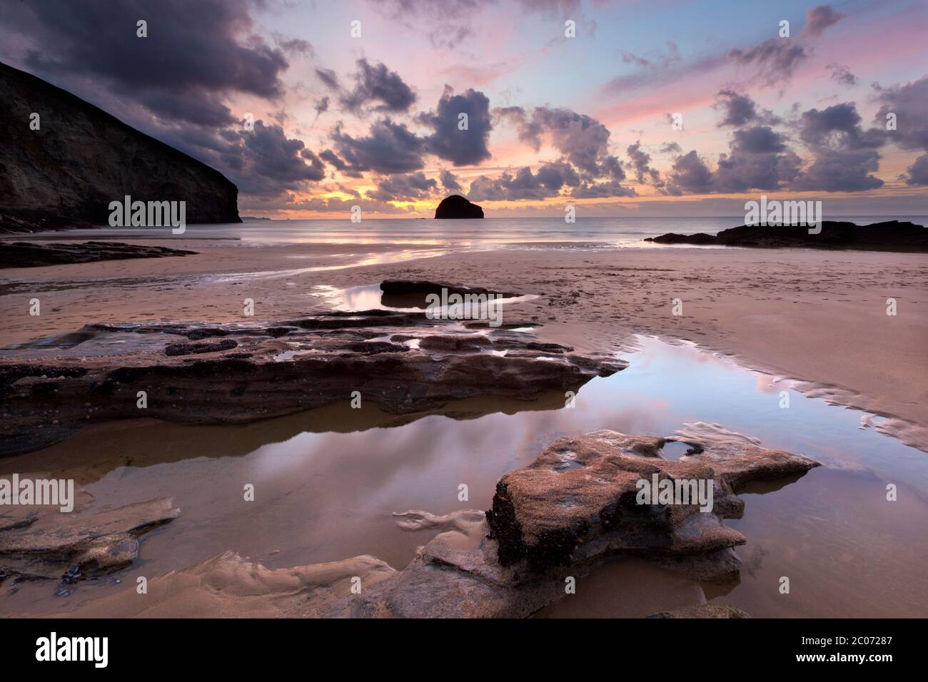 Sunset at low tide behind Dennis Point on Trebarwith Strand, Trebarwith, Cornwall, England, United Kingdom Stock Photo