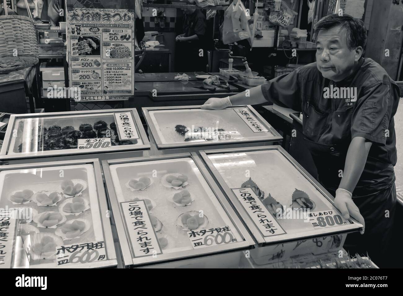 Old man selling seafood on a traditional Japanese fish market Stock Photo