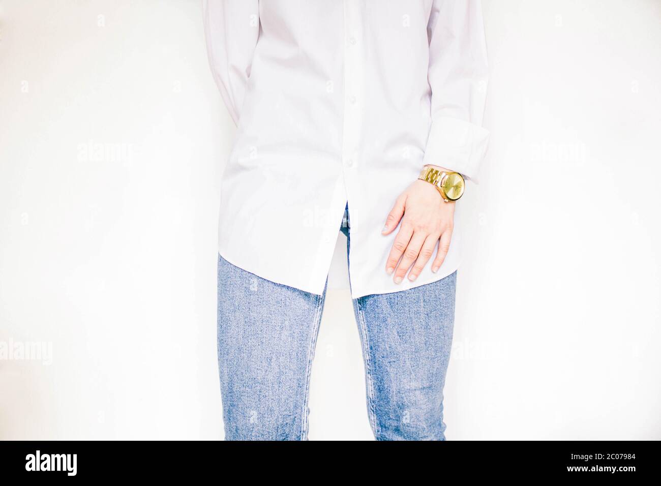 female body part, white shirt, jeans and watch on the wrist Stock Photo