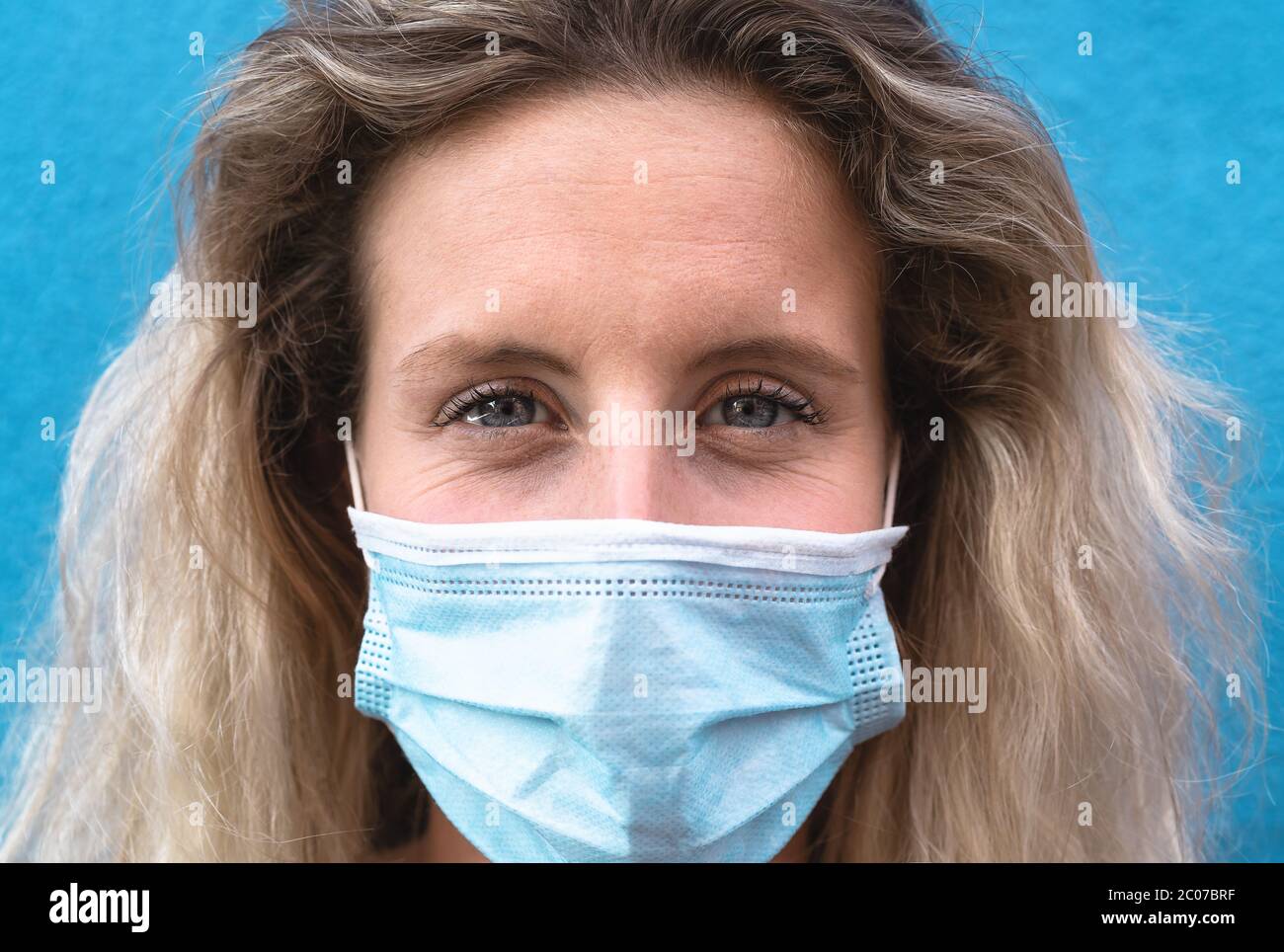 Young woman portrait wearing surgical face mask - People self quarantine for preventing and stop corona virus spread Stock Photo