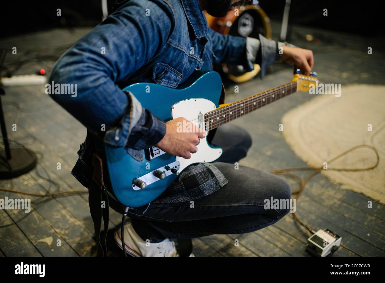Young guitarist tunes at thr concert. Stock Photo