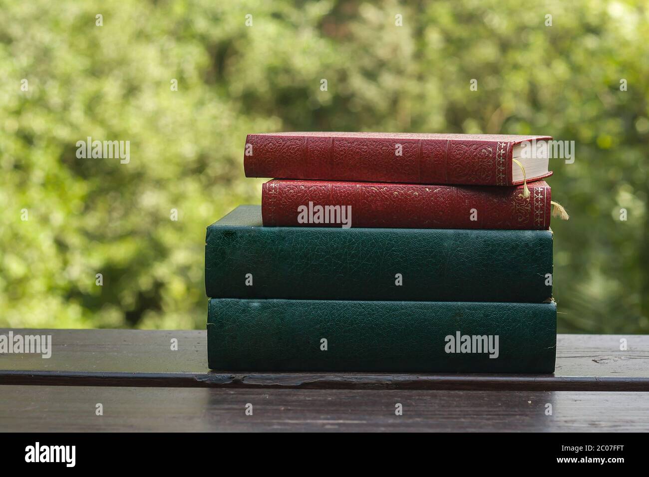 Pile of old books in the garden wooden table Stock Photo - Alamy