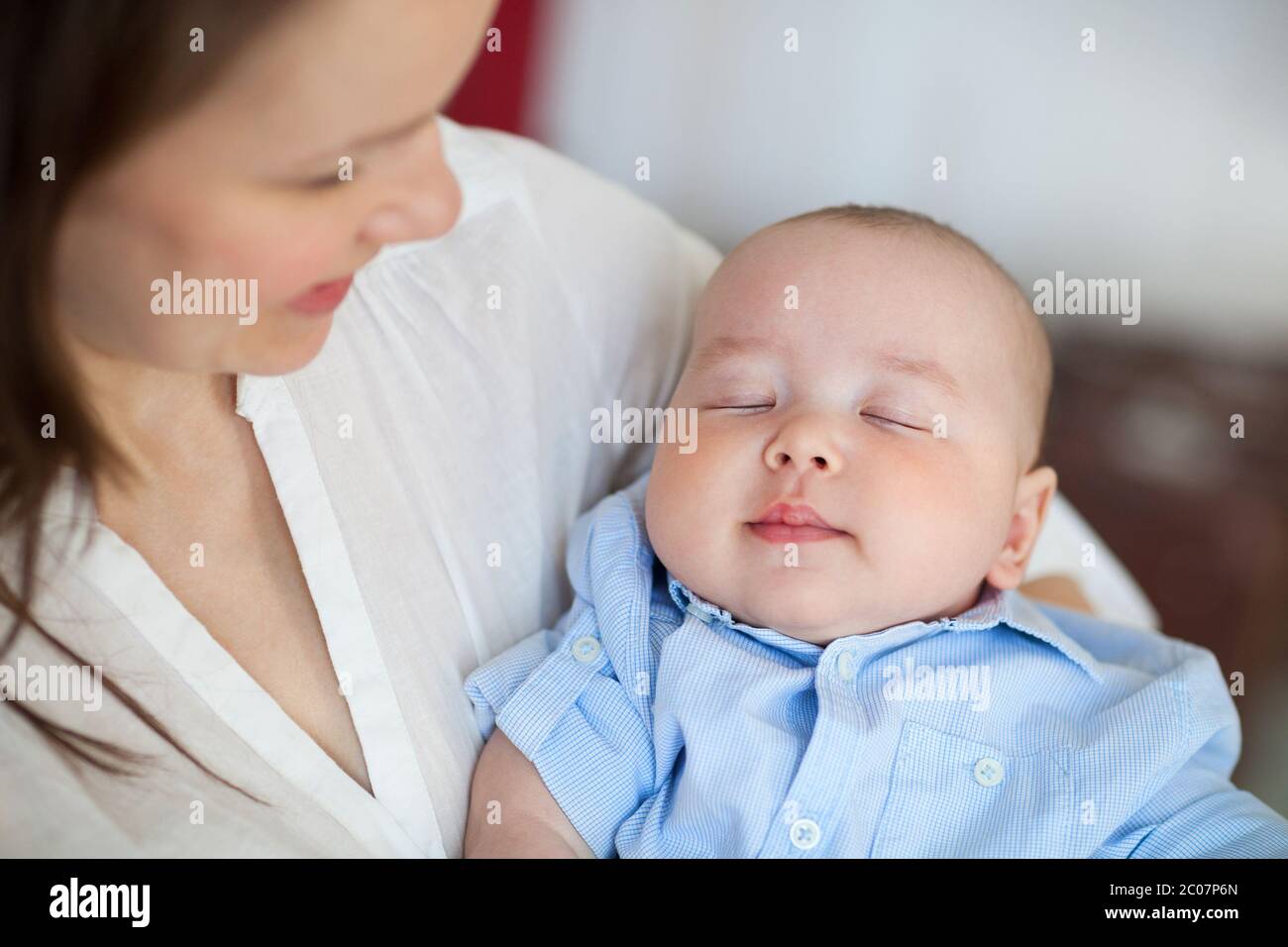 Baby boy falling asleep in the arms of her mother Stock Photo Alamy