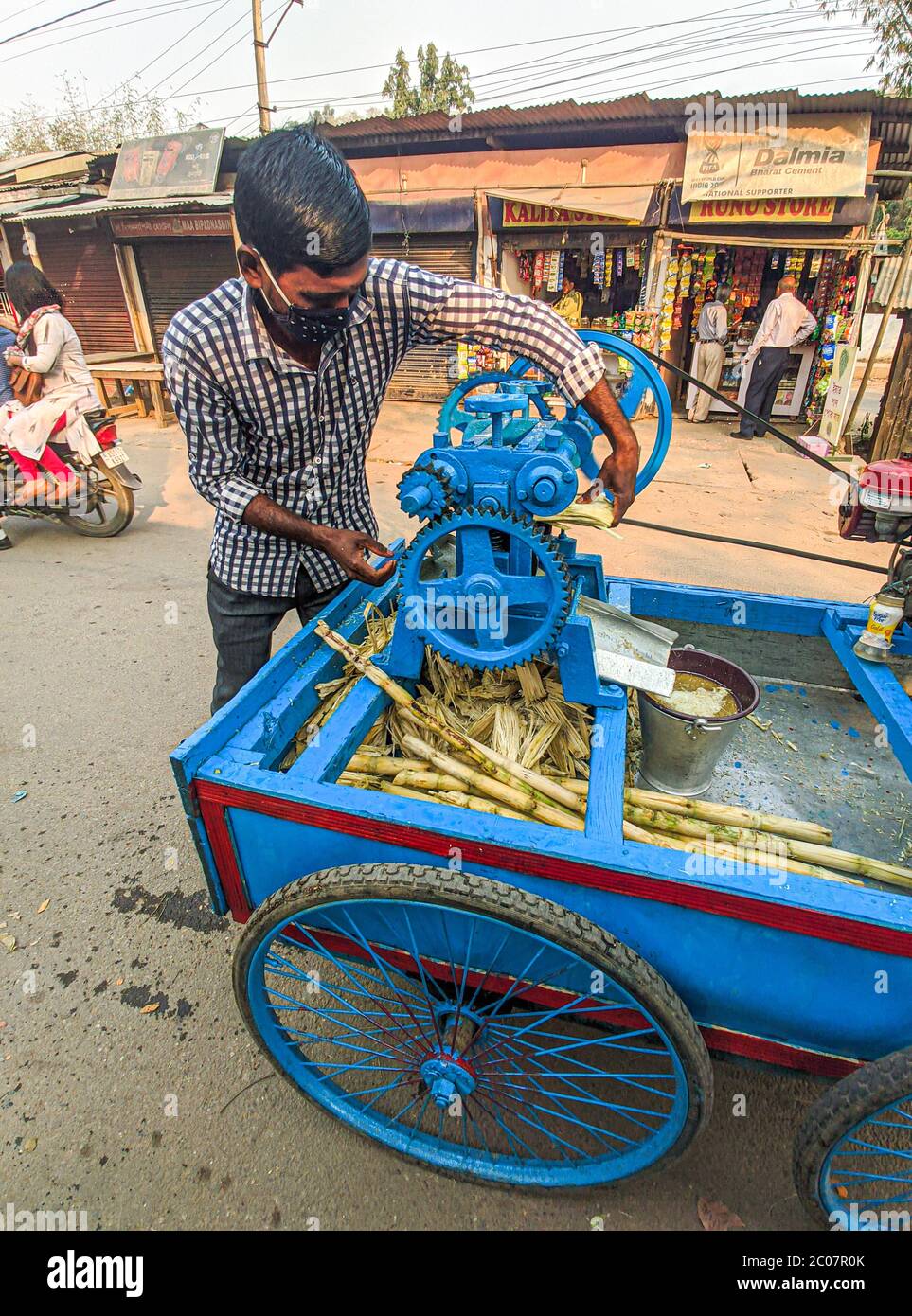 Street side sugarcane juice maker, making the juice by crashing the sugercanes. Stock Photo