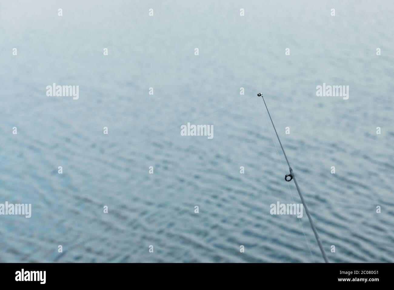 Detail of the fishing pole and the string by the water Stock Photo
