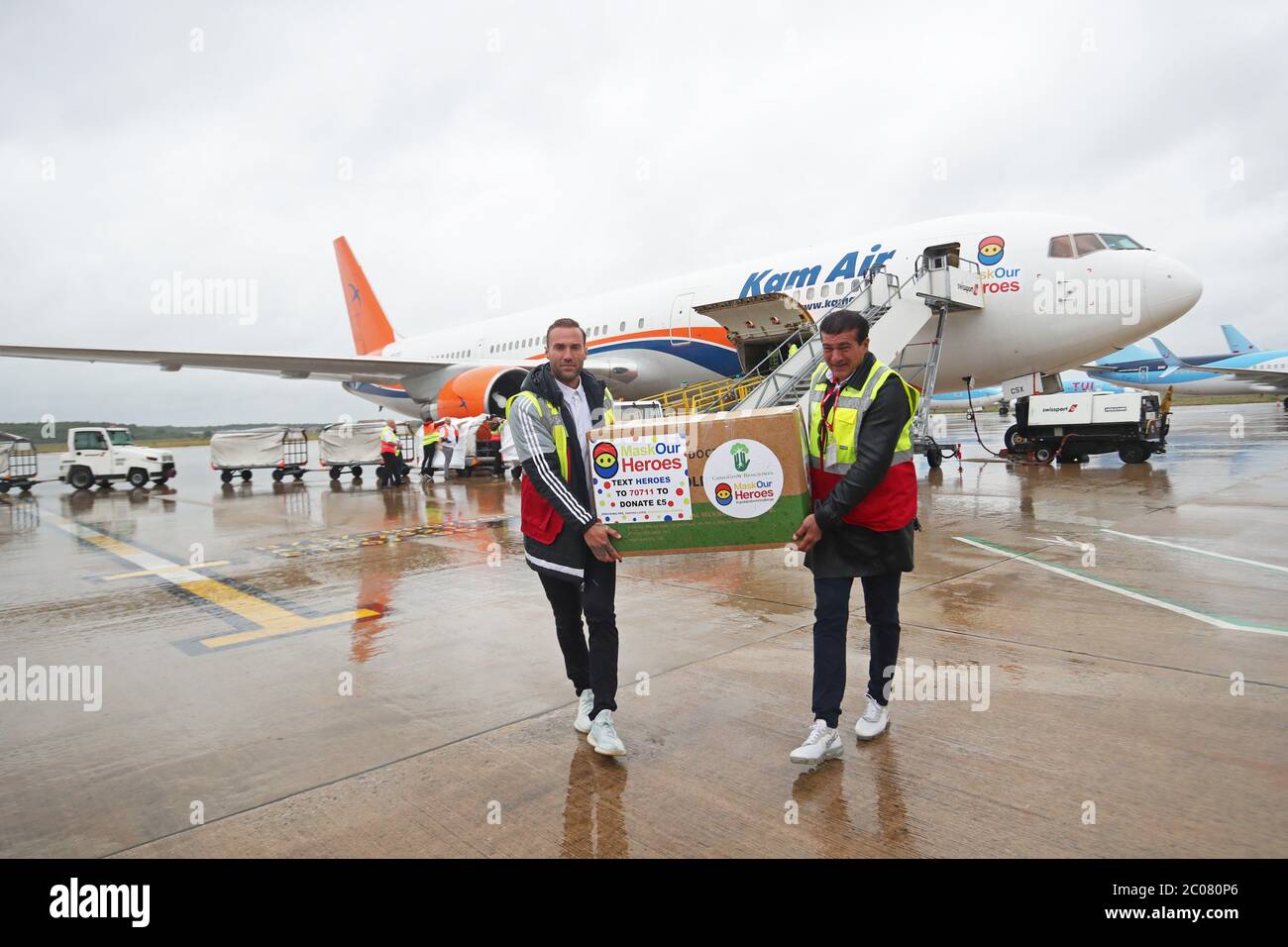 Calum Best (left) and Tamer Hassan help to unload boxes of Personal Protection Equipment (PPE) from a plane at Robin Hood Airport in Doncaster, South Yorkshire. ??30,000 worth of PPE has been donated to the Mask Our Heroes charity, which was set up by entrepreneur Matthew McGahan in the wake of the coronavirus outbreak to help supply frontline NHS and health workers with the protective equipment they need. Stock Photo