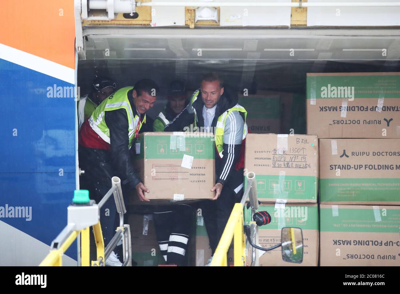 Calum Best (right) and Tamer Hassan help to unload boxes of Personal Protection Equipment (PPE) from a plane at Robin Hood Airport in Doncaster, South Yorkshire. ??30,000 worth of PPE has been donated to the Mask Our Heroes charity, which was set up by entrepreneur Matthew McGahan in the wake of the coronavirus outbreak to help supply frontline NHS and health workers with the protective equipment they need. Stock Photo