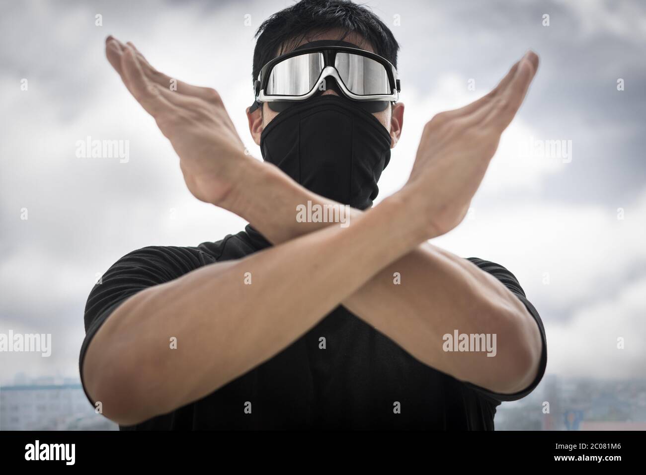 A chinese man covered in a mask standing outside protesting in the streets of hong kong. Bad air polltion awareness. Stock Photo